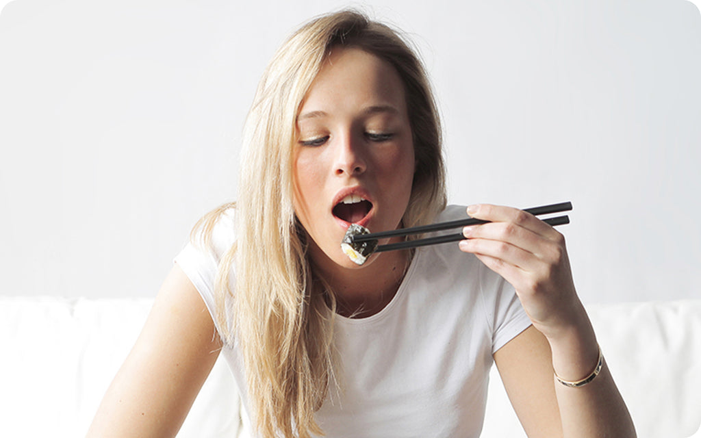 healthy woman eating sushi