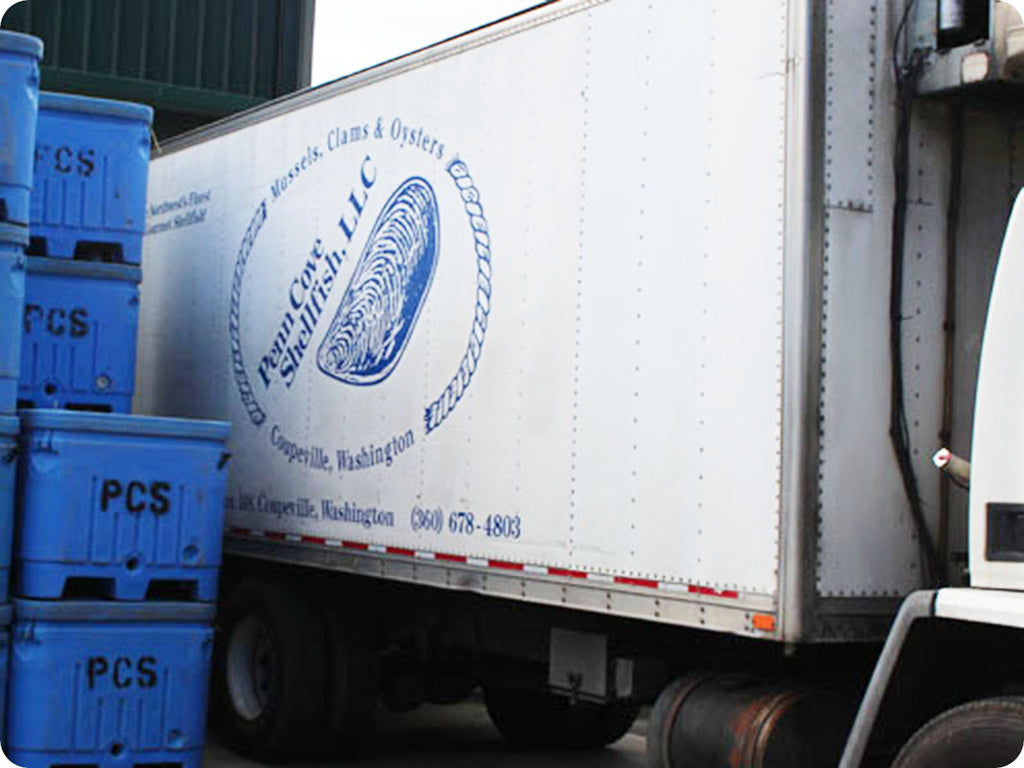 A distrubution truck from Penn Cove Shellfish, LLC. is loaded with blue cooled boxes.