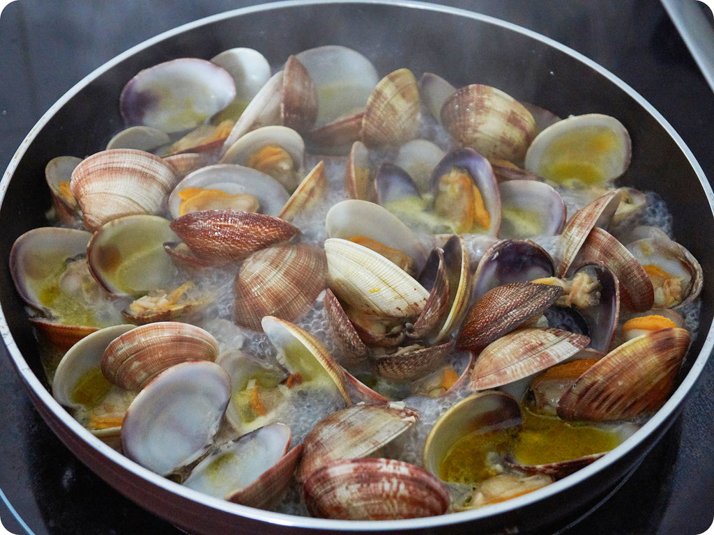 Manila clams being sauteed in butter and white wine.