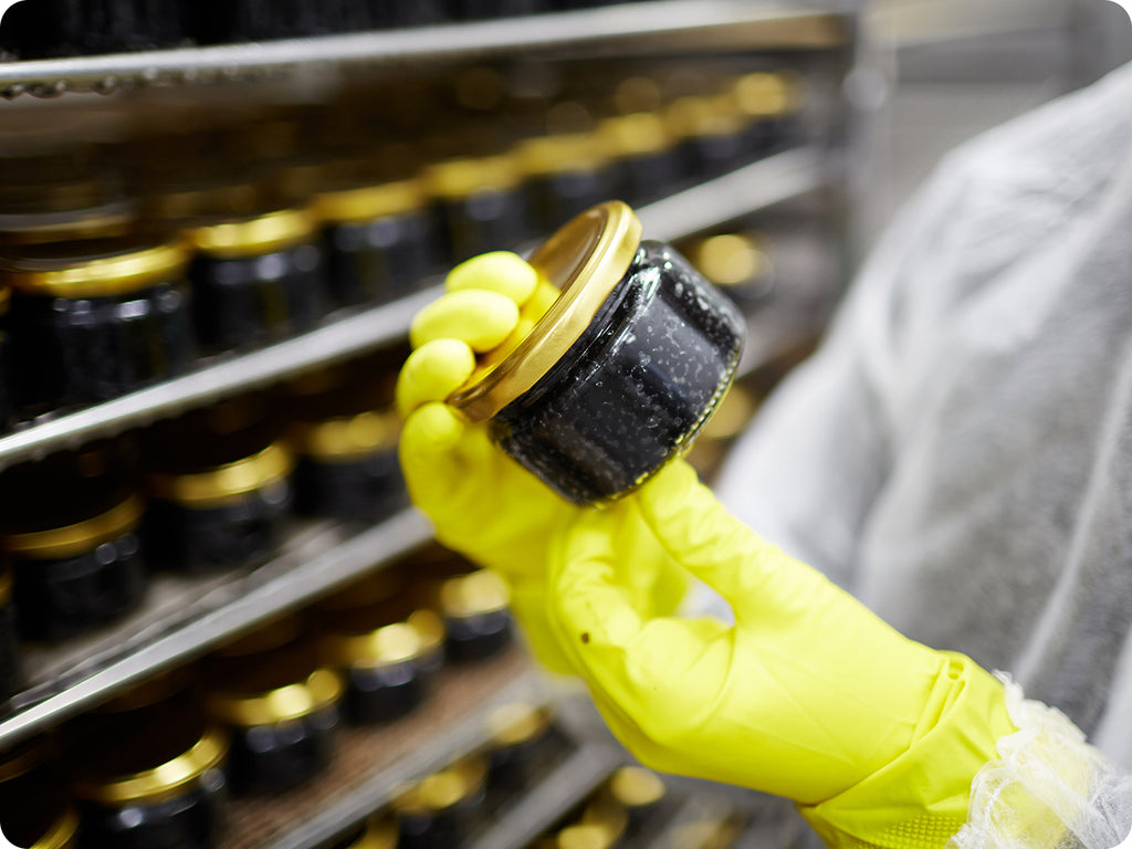 Jars of caviar are examined during production.