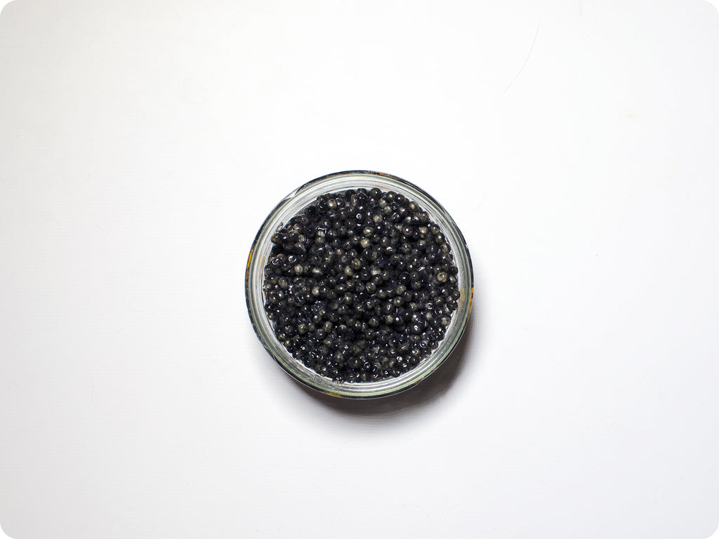 An arial shot of Sevruga Caviar in a glass jar.
